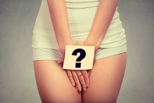 woman holding paper with question mark over her crotch. Health hygiene sexual education concept